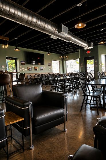 Modern restaurant interior with black chairs and industrial design.