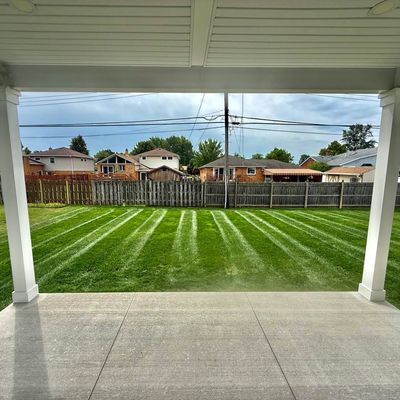 Freshly mowed backyard with clear stripes viewed from a porch.