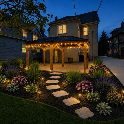 A backyard gazebo with pathway lights at dusk.