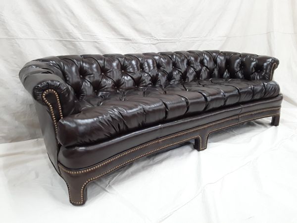 Luxurious dark brown leather Chesterfield sofa with tufted back and nailhead trim.