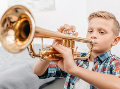 Boy playing a trumpet at the Norman Music Institute