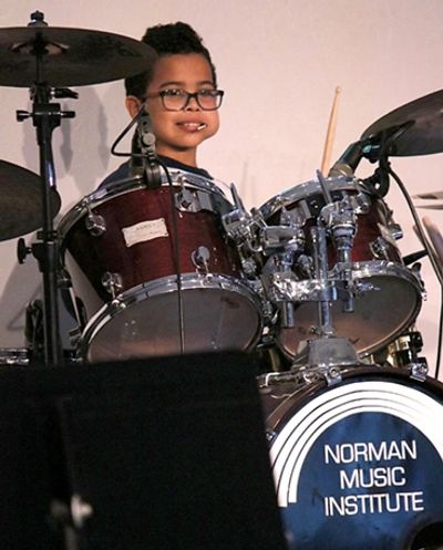 Young Male learning to play Drums at the Norman Music Institute