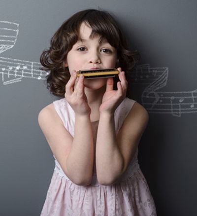Young Female learning to play the Harmonica at the Norman Music Insitute