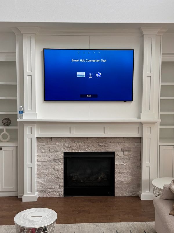 We mounted an 85” Samsung Frame TV above a wood-backed fireplace and installed a white box-Auburn wa