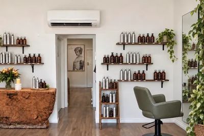 Inside Urban Hair & Co, Earlwood: haircare shelves, a sage green styling chair and timber console