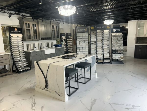 Modern showroom with marble island and cabinetry displays.