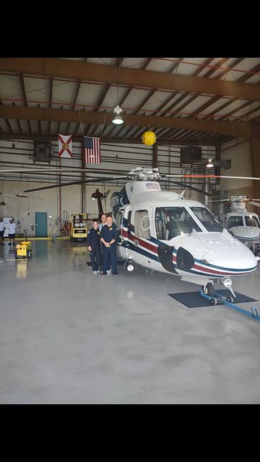 White helicopter parked inside a hangar