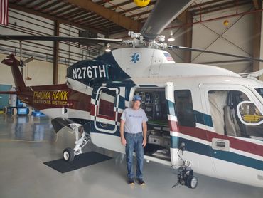 Man standing next to a white helicopter