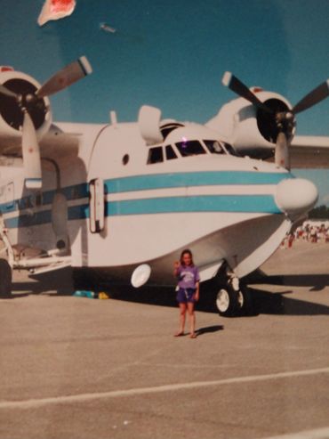 Large white and teal seaplane on land