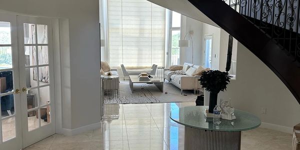 Elegant living room with spiral staircase and chandelier.