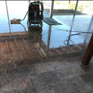 Floor polishing machine working on shiny marble tiles indoors.