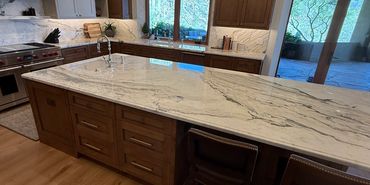 Spacious kitchen with marble countertops and wooden cabinetry.