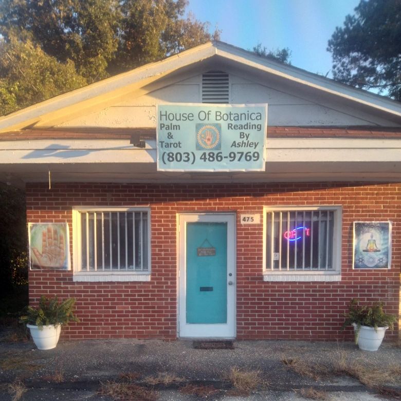 Brick building with Palm & Tarot Reading By Ashley written on it.
