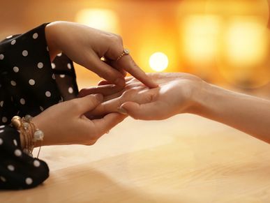 A psychic doing a palm reading on a client's hand.