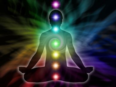 The silhouette of a man with chakra colors down his body and swirling colors of energy all around.