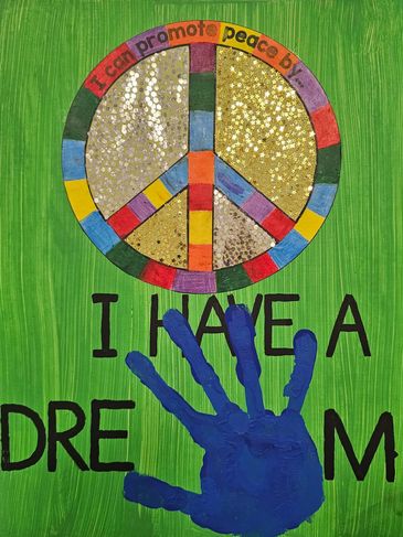 Colorful peace symbol with glitter and a blue handprint on green background.