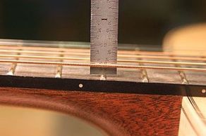 Checking string height during guitar set-up