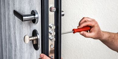 Locksmith van fully equipped with tools and locks, parked outside a Manchester residence.