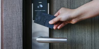 Close-up of a locksmith's hands installing a robust deadbolt on a wooden front door.