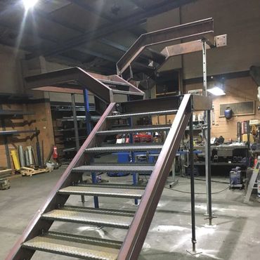 Metal staircase under construction in a workshop.