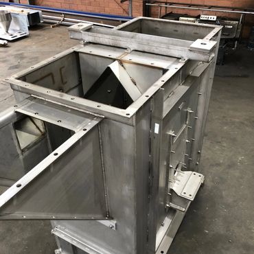 Large industrial metal container or hopper under construction.