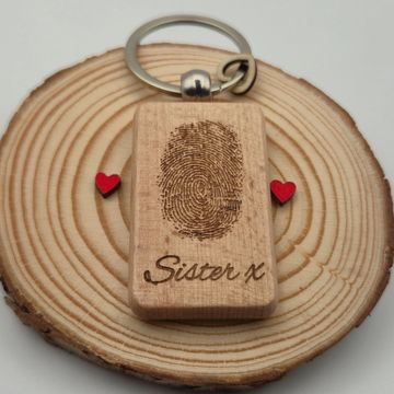 Wooden keychain with a fingerprint and "Sister x" engraved on it.