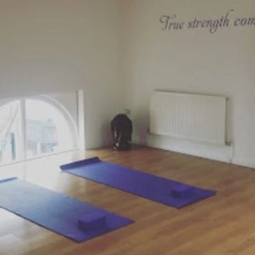 Revitalise Yoga Studio Brighton and Hove purple yoga mats and blocks next to a half-moon window.