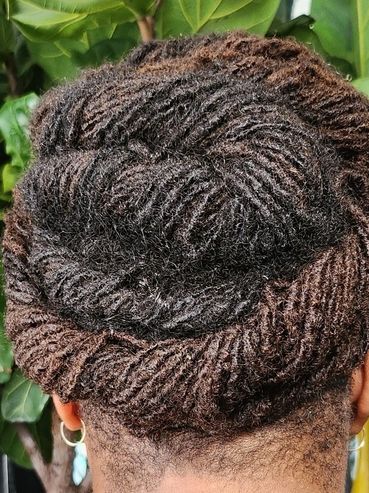 Intricate twisted hairstyle with detailed patterns on natural hair.
