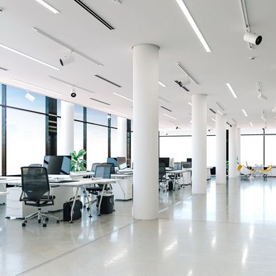 Modern, spacious office with white pillars and desks.