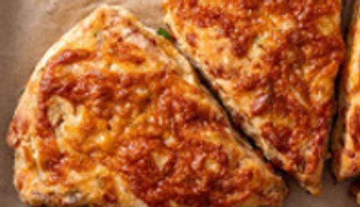 Golden-brown cheesy baked scones sliced into wedges.