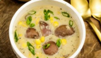 Creamy chicken liver soup garnished with green onions in a white bowl.