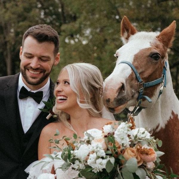 Happy couple with a horse at their wedding.