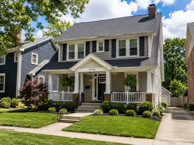 A well-maintained two-story house with a front porch and lush green lawn.