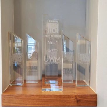 A set of transparent awards displayed on a wooden shelf.
