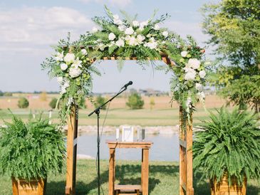 Outside wedding arbor decorated in front of the small pond.