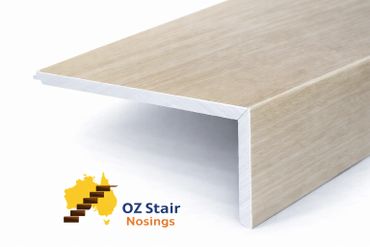 Light wood-colored stair nosing with white edges, branded OZ Stair Nosings.