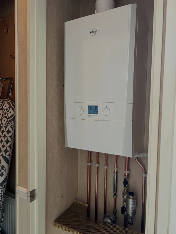 Wall-mounted boiler with copper pipes.
