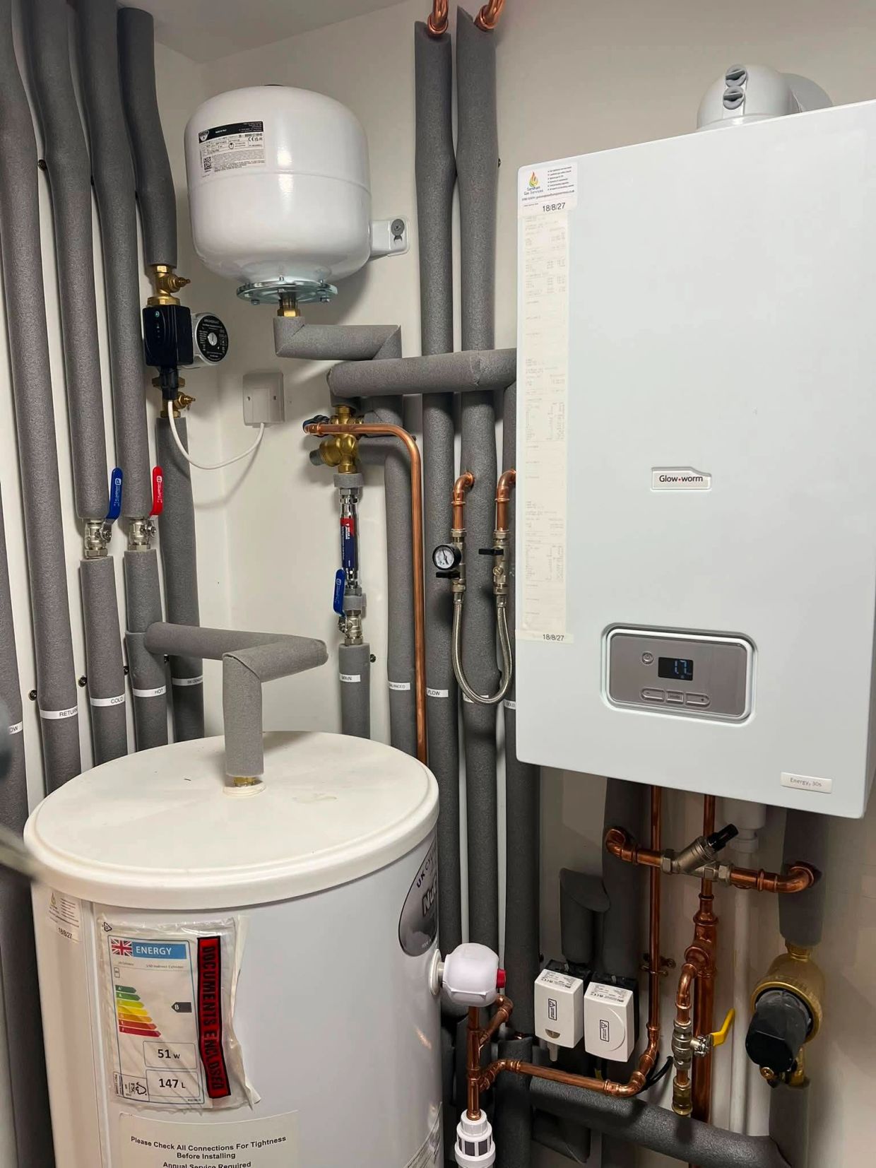 Modern boiler system with insulated pipes and control valves.