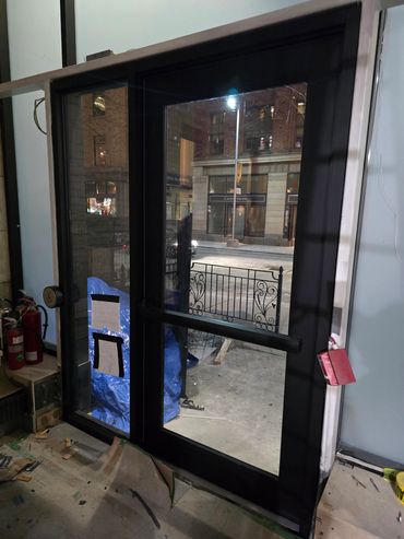 Black framed glass door downtown indoors near window.