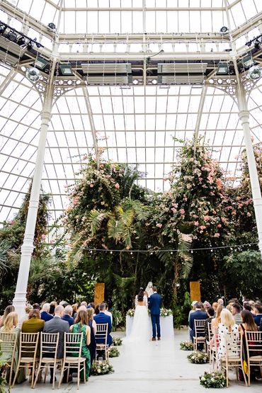 Tall blossom palm trees backdrop for wedding at Sefton Palm House ceremony