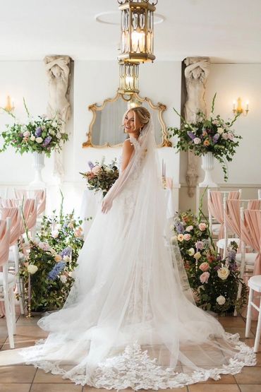 Bride down the aisle with pastel wedding flowers standing in a floral meadow at Plas Maenan Wales