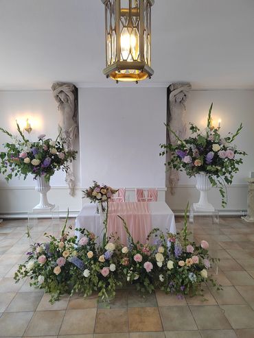 Large fresh floral meadow for wedding ceremony in pastel colours and matching 5.5ft urns