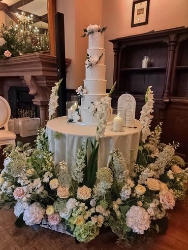 Romantic and garden style cake table meadow made from fresh flowers in baskets