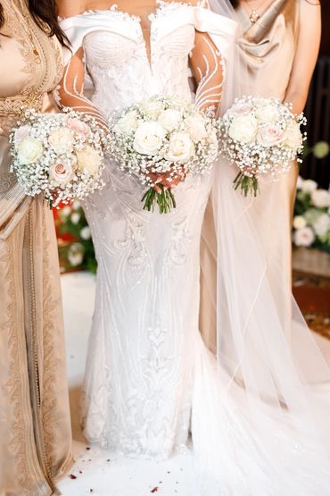 Close up of Bridesmaid bouquets with white and nude roses and gypsophila