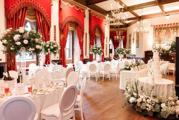 Wedding breakfast flowers on tall stands and cake table flowers at peckforton castle