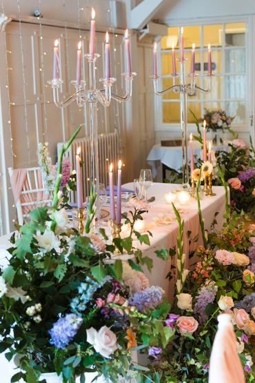 Sweetheart table designed with tall garden-style pastel flowers and candlelight at plas maenan