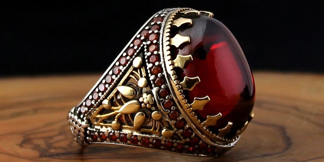 Ornate ring with red gemstone and gold detailing.