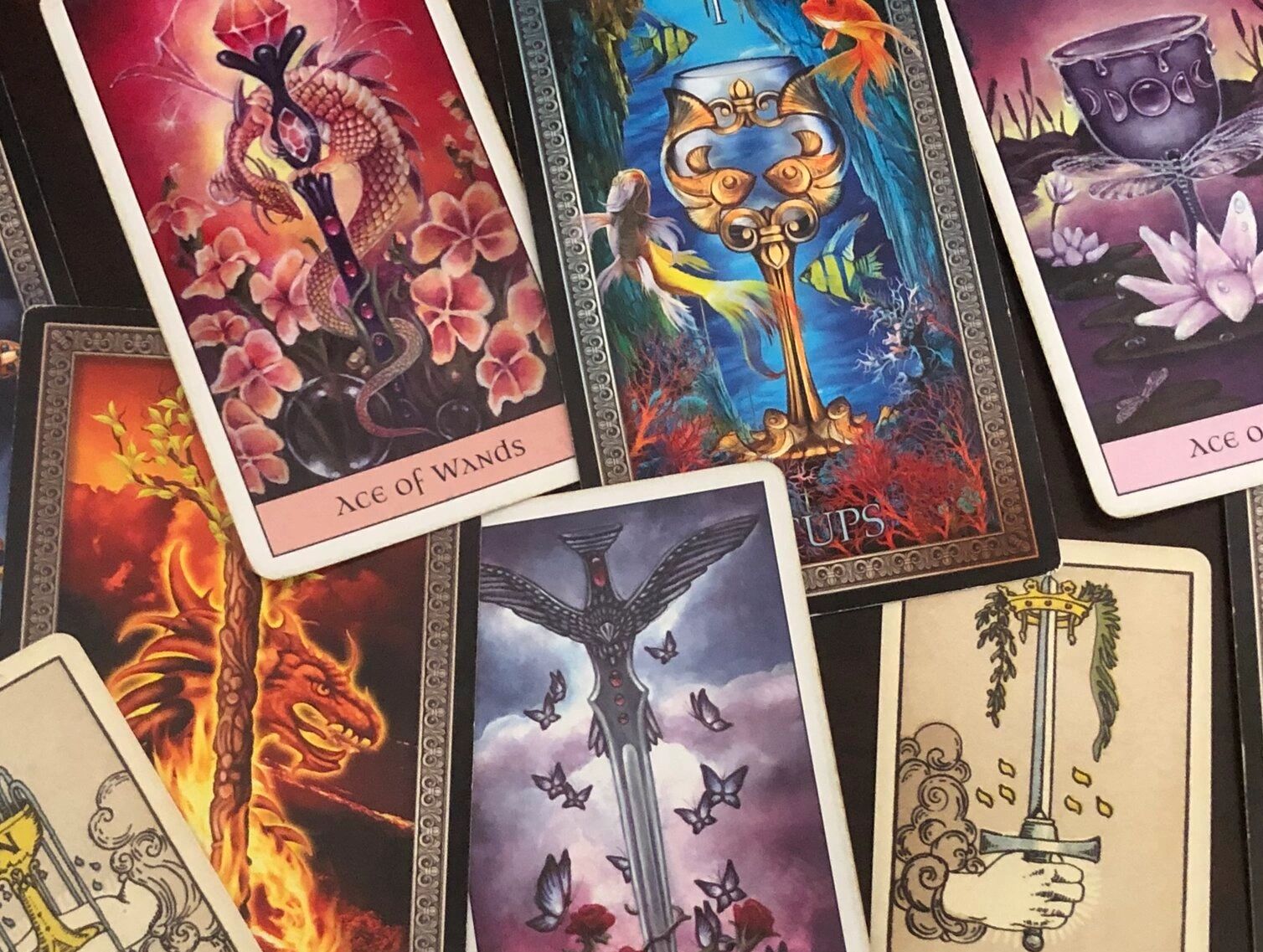 A vibrant mix of tarot cards featuring elements like dragons, keys, and butterflies.
