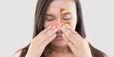 Patient experiencing sinus pressure, holding their head with discomfort