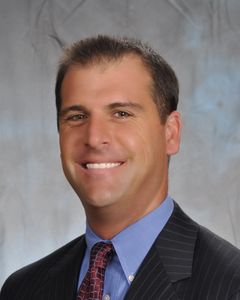 Portrait of a man in a suit smiling.